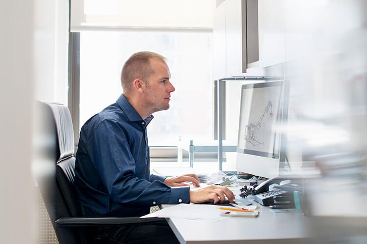 male engineer reviewing floveyor powder conveyor drawing on computer monitor