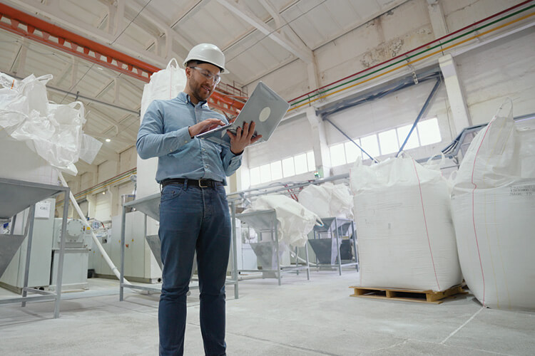 man in factory with fibcs in background